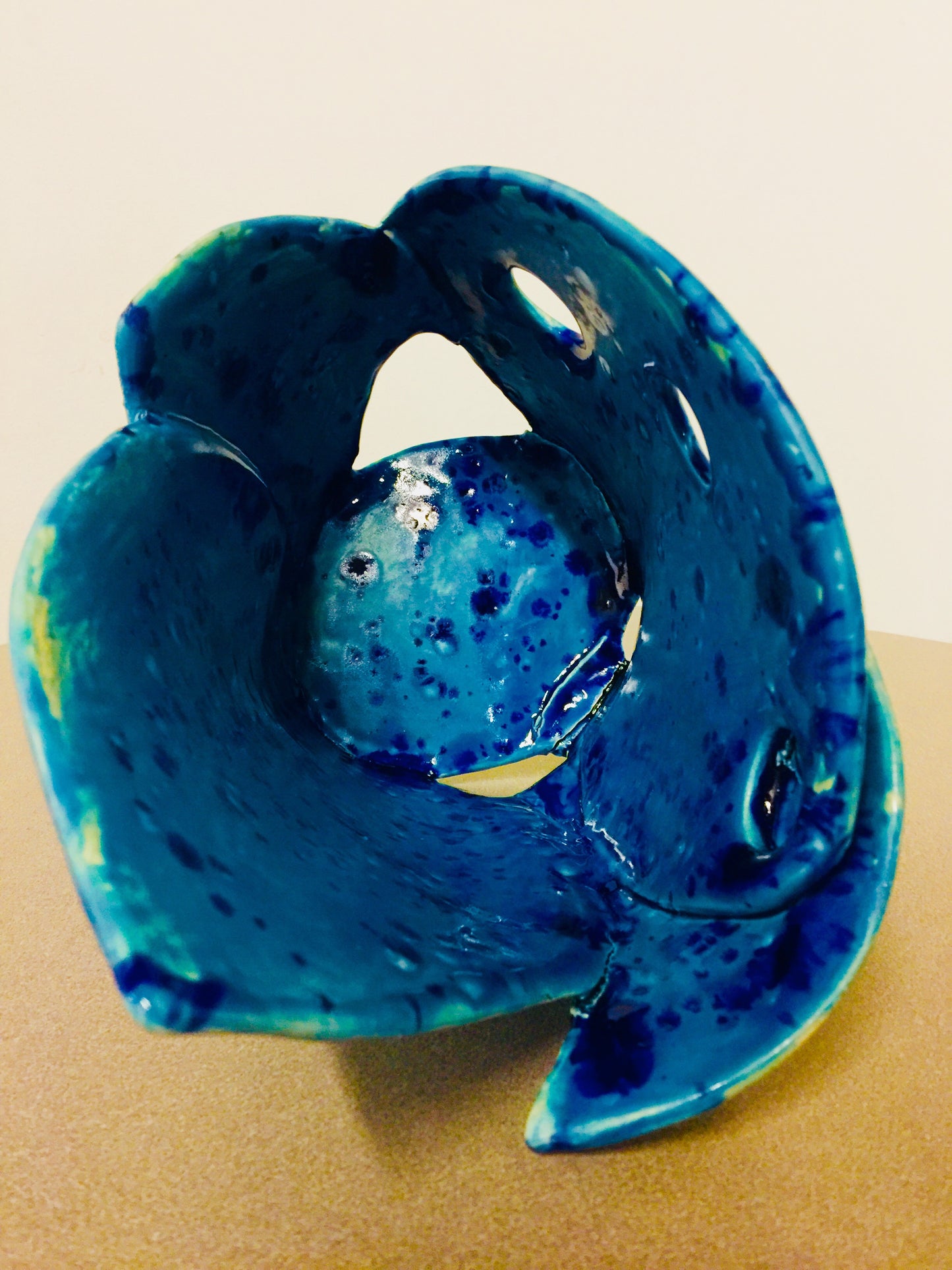 This contemporary turquoise vase is a handmade piece created by Shahla Reynolds. It straight lines give the piece an elegance and stylish feel, while elevating the surrounding space it occupies. It resembles a blooming tulip with gentle blue color that brings a feel of calm and serenity. its shape and unique color fits within any rooms decor. The surface of the vase has some texture and speckles of darker color of gaze adding to its dimensional look. The turquoise Sea Mist is 11” Wide x 13” High.