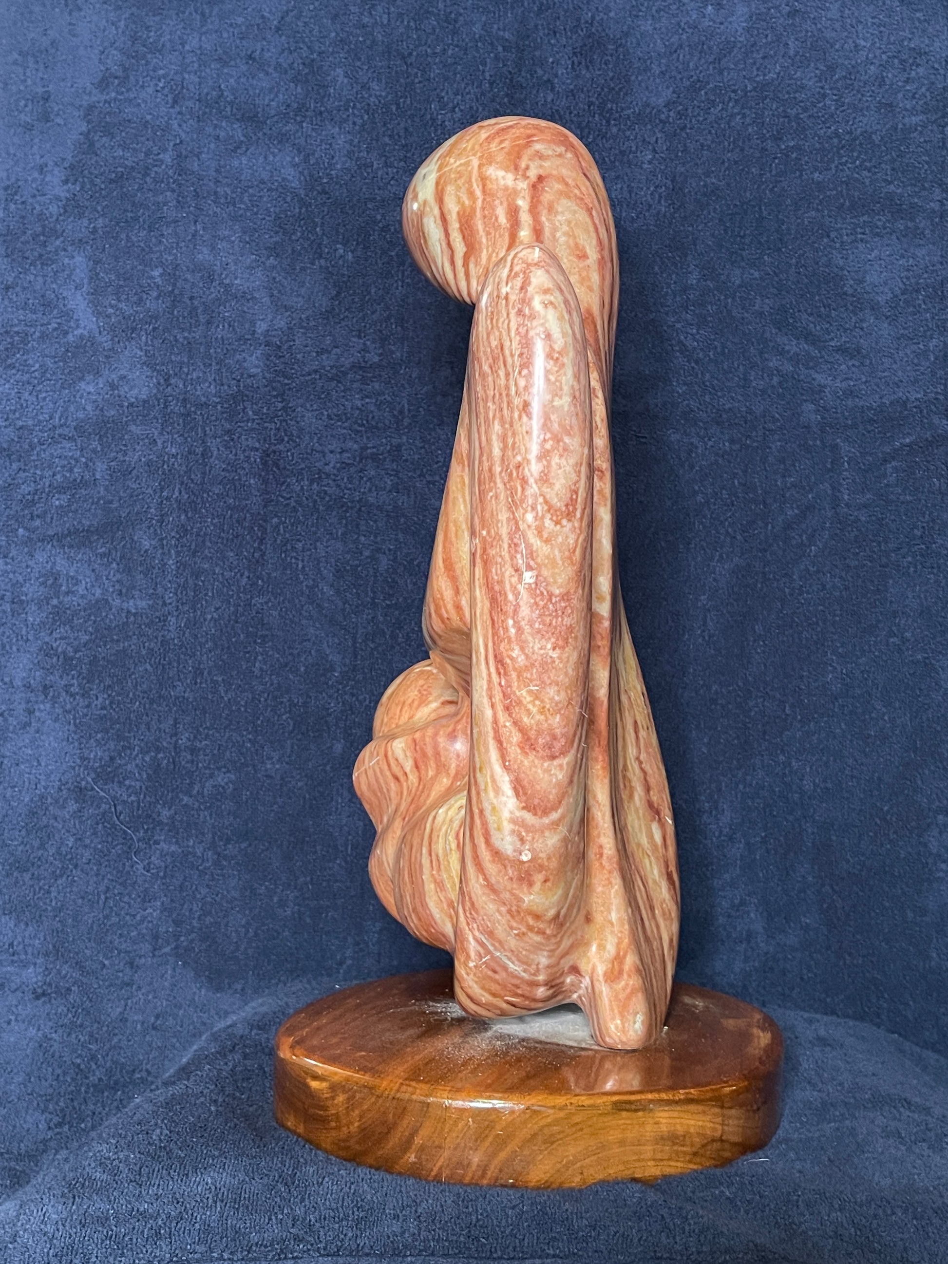 Cherish is carved from Utah red alabaster. Its smooth surface conveys a sense of tranquility and grace. represents the eternal bond of love between a mother and child. This is the first time a human being experiences love through the gentle touch of his/her mother. That is an everlasting love for both of them.

This sculpture was designed and carved by Shahla Rahimi Reynolds.

This piece is: 10" Width x 17 1/2" Height x 6 1/2" Depth.