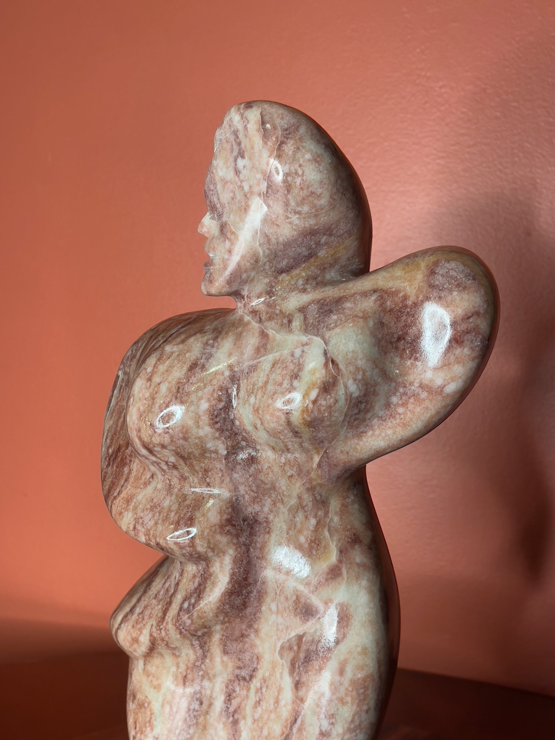 A hand-carved Utah alabaster sculpture depicting Venustus (pronounced veh-NUSS-tuss), the Goddess of Love, showcasing an elegant and refined female form. It represents the qualities of beauty, confidence, and self-assurance, embodying a woman who confidently navigates her own journey through life. The sculpture reflects themes of independence and personal strength, celebrating resilience and empowerment.

Venustus is an original design created by Shahla Rahimi Reynolds.

The piece is 13" H x 8" W x 3.5" D.
